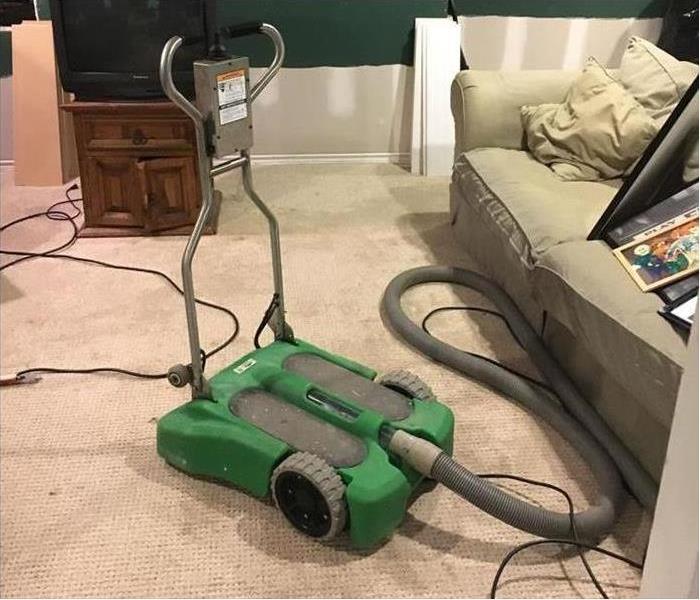 A portable wet vac driving the carpet in this home
