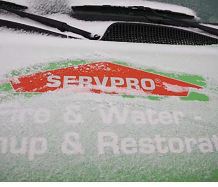 A SERVPRO van covered in snow
